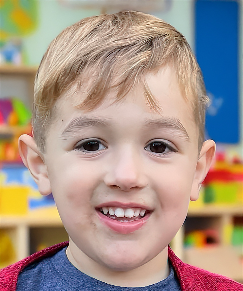 A delighted preschooler grins widely, radiating joy and enthusiasm in a vibrant learning atmosphere.