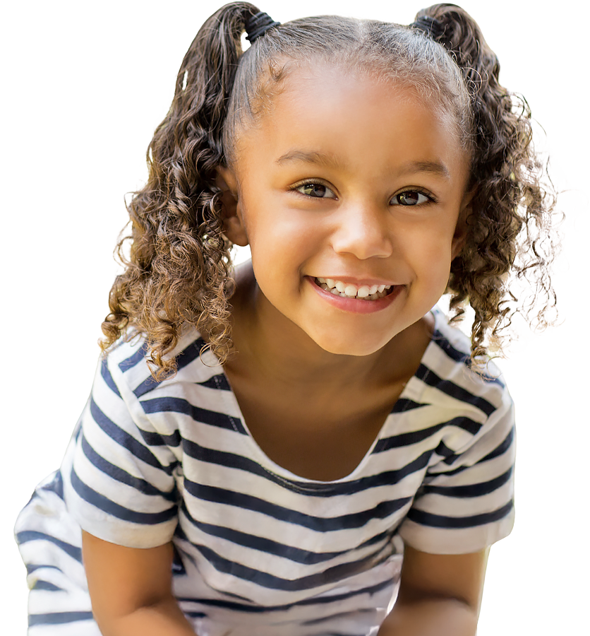 A cheerful girl with curly hair smiles brightly at the camera, wearing a striped dress in a colorful, playful environment.